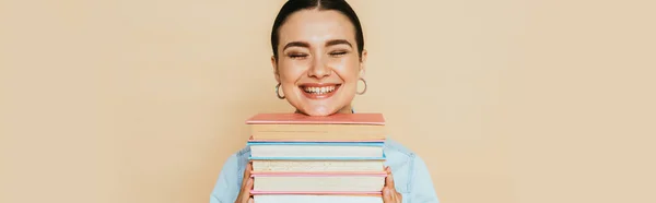 Student in denim shirt with books smiling isolated on beige, panoramic shot — Stock Photo