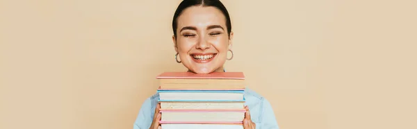 Estudante em camisa jeans com livros sorrindo isolado em bege, tiro panorâmico — Fotografia de Stock