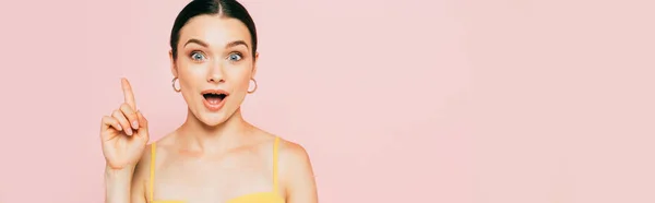 Surprised brunette young woman showing idea gesture isolated on pink, panoramic shot — Stock Photo