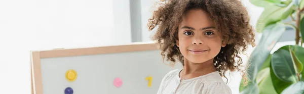 Horizontal crop of curly african american child looking at camera — Stock Photo
