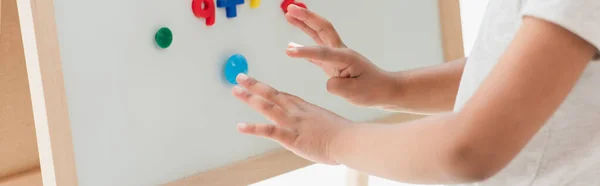 Horizontal crop of african american kid touching magnetic easel with magnets — Stock Photo