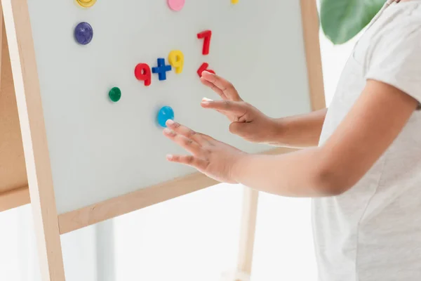 Vue recadrée d'un enfant afro-américain touchant un chevalet magnétique avec des aimants — Stock Photo