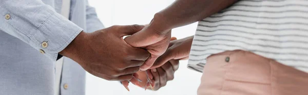 Cultivo panorámico de marido y mujer afroamericanos tomados de la mano - foto de stock