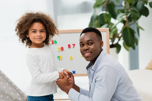 African american father and daughter holding hands at home — Stock Photo