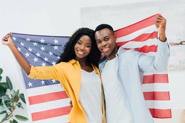 Coppia afro-americana che tiene bandiera d'America — Foto stock