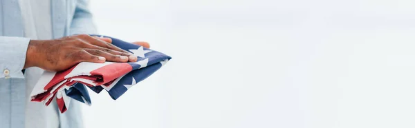 Horizontal crop of african american man holding flag of america isolated on white — Stock Photo