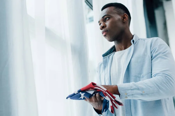 Homem americano africano segurando bandeira da América e olhando para longe — Fotografia de Stock