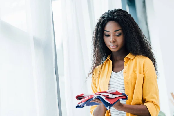 Morena mujer afroamericana mirando la bandera de América - foto de stock