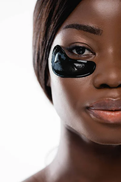 Vue recadrée de femme afro-américaine avec des patchs hydrogel sur le visage isolé sur blanc — Photo de stock