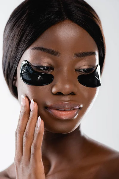 Portrait of african american naked woman with hydrogel eye patches on face isolated on white — Stock Photo