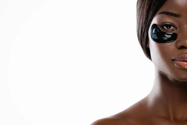 Обрізаний вид на афроамериканську голу жінку з гідрогелевими плямами очей на обличчі ізольовано на білому — стокове фото