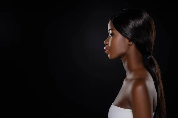 Vista lateral de mujer afroamericana aislada en negro - foto de stock
