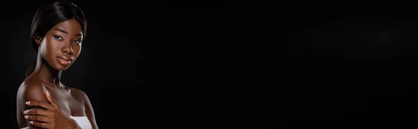Африканская американка смотрит на камеру, изолированную на черном, панорамном снимке — стоковое фото