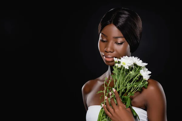Mujer afroamericana con crisantemos blancos aislados en negro - foto de stock