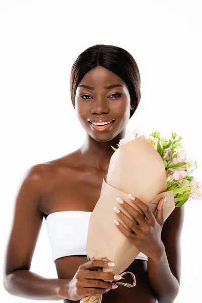 Mujer afroamericana sonriendo mientras sostiene ramo de flores aisladas en blanco - foto de stock