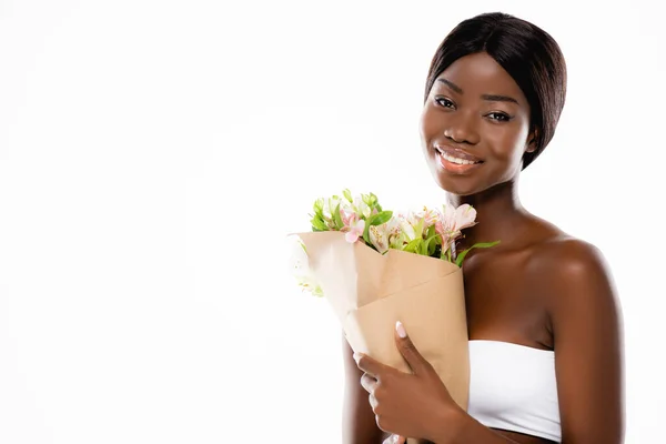 African american woman smiling while holding bouquet of flowers isolated on white — Stock Photo