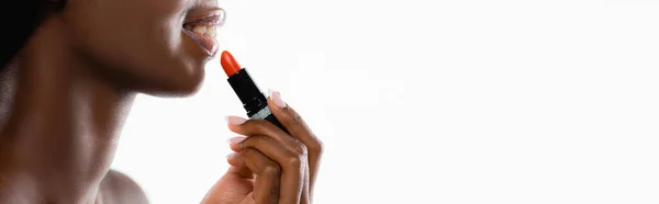 Vue recadrée de femme nue afro-américaine appliquant rouge à lèvres isolé sur blanc, panoramique — Photo de stock