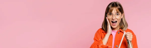 Panoramic concept of shocked woman in sunglasses looking at camera isolated on pink — Stock Photo