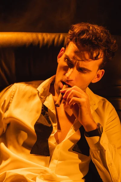 Mann im Anzug hält Zigarre in der Hand und schaut schwarz weg — Stockfoto
