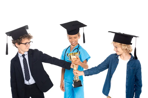 Bambini in berretti di laurea vestiti con costumi di diverse professioni con trofeo d'oro isolato su bianco — Foto stock