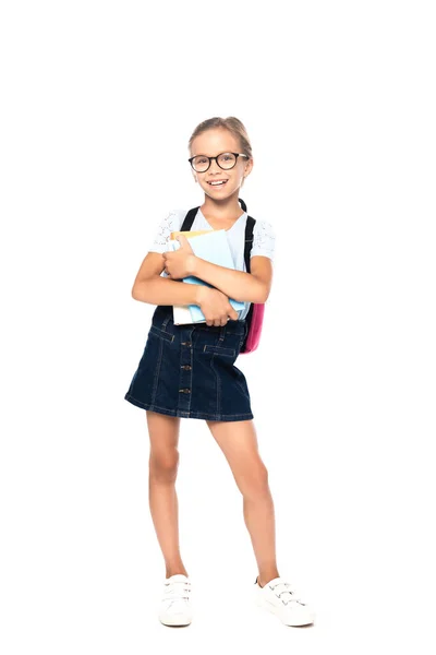 Schoolkid in glasses holding books while standing and looking at camera isolated on white — Stock Photo