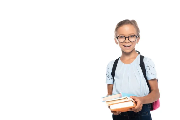 Aufgeregtes Schulkind mit Brille, Bücher in der Hand, während es isoliert auf weiß in die Kamera blickt — Stockfoto