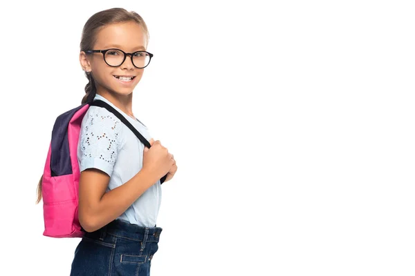 Écolière en lunettes regardant caméra et toucher sac à dos isolé sur blanc — Photo de stock