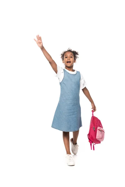 African american schoolkid screaming while holding backpack and standing with raised hand isolated on white — Stock Photo