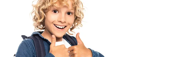Panoramic shot of curly blonde schoolboy looking at camera and showing thumbs up isolated on white — Stock Photo