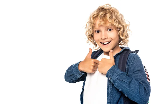 Curly blonde schoolboy looking at camera and showing thumbs up isolated on white — Stock Photo