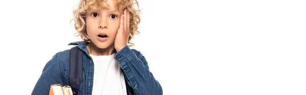 Panoramic crop of shocked blonde schoolboy touching face isolated on white — Stock Photo