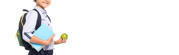 Панорамний урожай школяра з рюкзаком і книгою, що тримає яблуко ізольовано на білому — стокове фото
