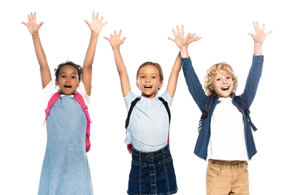 Aufgeregten multikulturellen Schulmädchen und Schuljungen mit erhobenen Händen isoliert auf weiß — Stockfoto