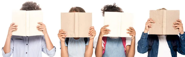 Horizontal image of multicultural schoolgirls and schoolboys covering faces with books isolated on white — Stock Photo