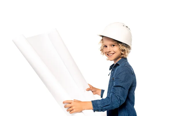 Blonde boy in safety helmet and costume of architect holding blueprint and looking at camera isolated on white — Stock Photo