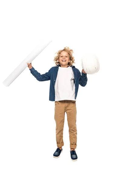 Кудрявый мальчик в костюме архитектора, держащего защитный шлем и чертеж во время прыжка изолированным на белом — стоковое фото