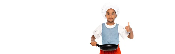 Панорамна концепція афроамериканської дитини в костюмі шеф-кухаря, що показує великий палець вгору, тримаючи сковороду ізольовану на білому — стокове фото
