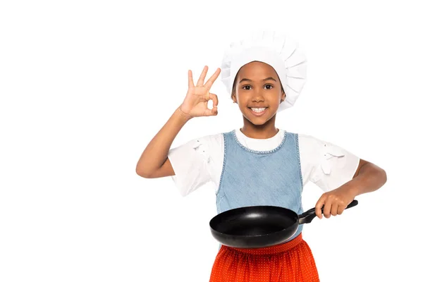 African american kid in costume of chef showing ok sign while holding frying pan isolated on white — Stock Photo