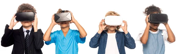 Panoramic shot of multicultural kids dressed in costumes of different professions touching virtual reality headsets isolated on white — Stock Photo