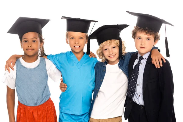 Enfants multiculturels en casquettes de graduation vêtus de costumes de différentes professions isolés sur blanc — Photo de stock