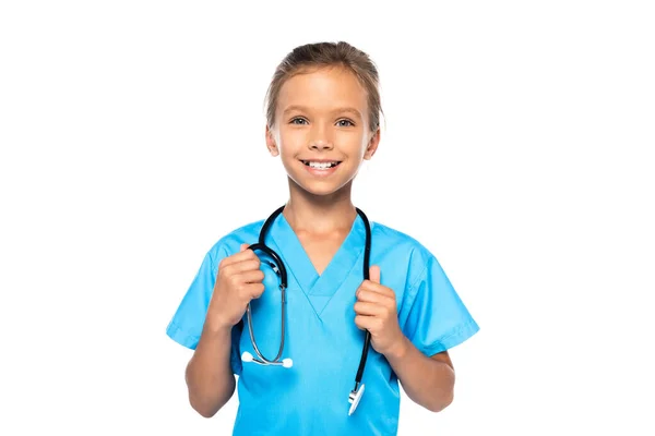 Child in costume of doctor touching stethoscope and looking at camera isolated on white — Stock Photo