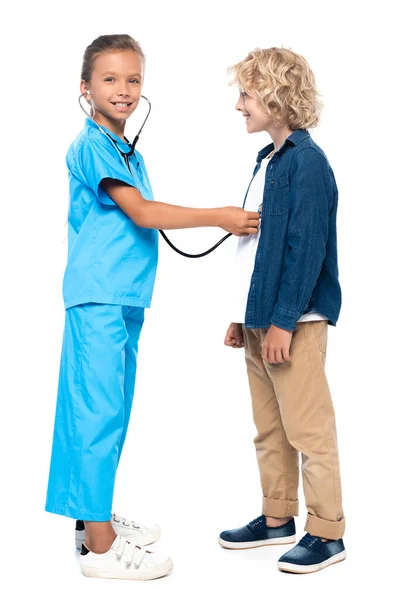 Child in costume of doctor examining blonde and curly boy isolated on white — Stock Photo