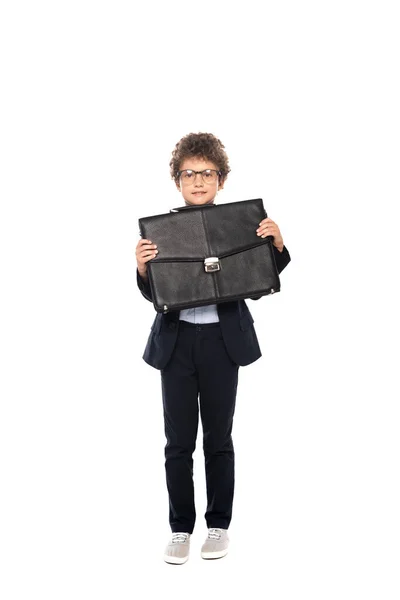 Niño rizado en ropa formal y gafas con maletín aislado en blanco - foto de stock