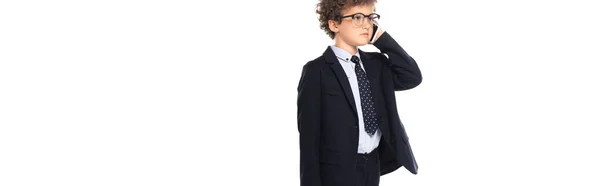 Panoramic crop of curly boy in suit and glasses talking on smartphone isolated on white — Stock Photo