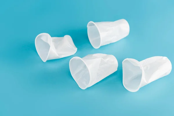 Einweg-Kunststoff zerknüllte Tassen auf blauem Hintergrund — Stockfoto