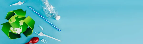 Top view of recycling symbol near plastic rubbish on blue background, panoramic shot — Stock Photo