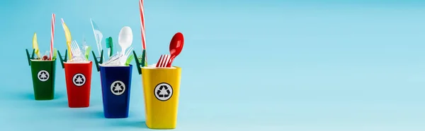 Multicolored recycling bins with plastic on blue background, panoramic shot — Stock Photo