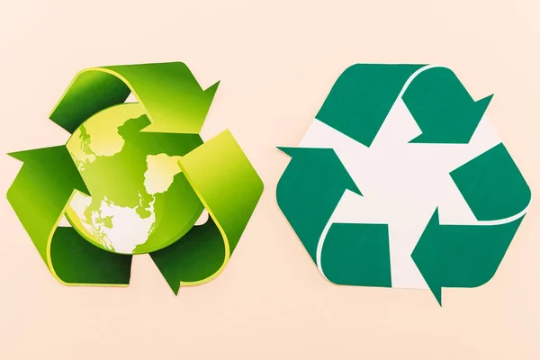 Vue de dessus des symboles de recyclage vert avec planète isolée sur beige — Photo de stock