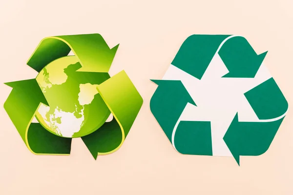 Vista superior de símbolos de reciclagem verde com planeta isolado em bege — Fotografia de Stock