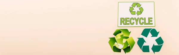 Vista superior de símbolos de reciclagem verde com planeta e reciclar palavra isolada em bege, tiro panorâmico — Stock Photo